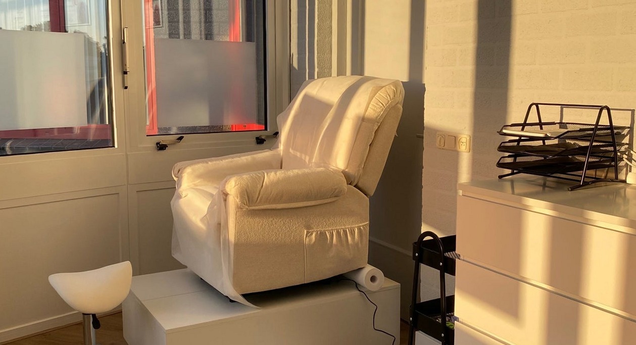 Witte pedicurestoel bij de ramen van de salon