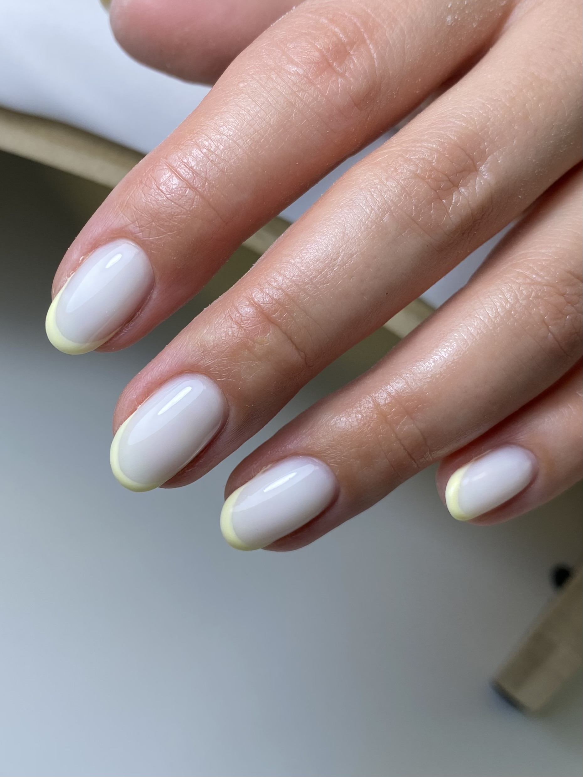 Ronde nagels in melkwit met een zachtgele French